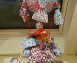 Nähanleitung und Schnittmuster gestaltet als PDF-E-Book von shesmile für einen Adventskalender und Kinderzimmerdeko Adventsballon in Form eines Heißluftballons. 24 kleine Geschenke oder ein Musikwürfel finden ihren Platz an den Halteschlaufen am oder