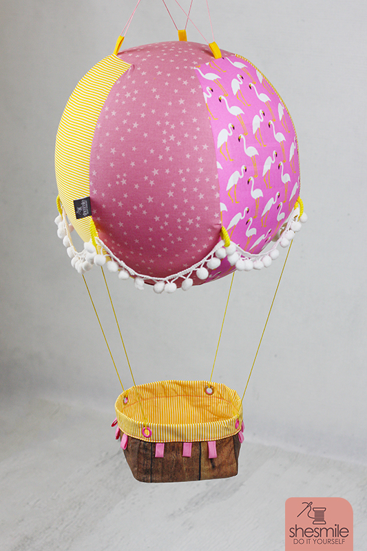 Ein Adventskalender Adventsballon mit Flamingos für meine Tochter. Nähanleitung und Schnittmuster gestaltet als PDF-E-Book von shesmile für einen Adventskalender und Kinderzimmerdeko Adventsballon in Form eines Heißluftballons. 24 kleine Geschenke oder ein Musikwürfel finden ihren Platz an den Halteschlaufen am oder im Körbchen.