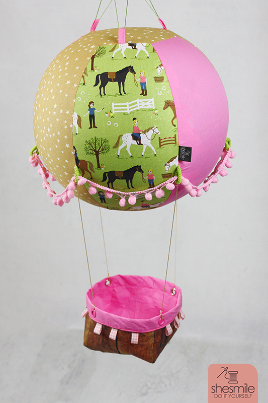 Ein Adventskalender Adventsballon mit Pferden für meine Tochter. Nähanleitung und Schnittmuster gestaltet als PDF-E-Book von shesmile für einen Adventskalender und Kinderzimmerdeko Adventsballon in Form eines Heißluftballons. 24 kleine Geschenke oder ein Musikwürfel finden ihren Platz an den Halteschlaufen am oder im Körbchen.