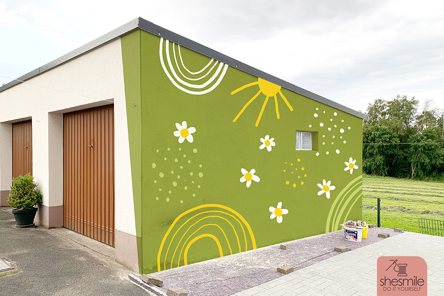 Außenwand verspachteln und mit Moltofil Außen verputzen, Risse und losen Untergrund sanieren, mit einem Wandbild bunt streichen, verschönern und anmalen. Konturen zeichnen mit dem Edding 950 Industrie Pastenmarker. Außenwand im Garten gestalten (Teil 3 der shesmile SchönerWohnen-Serie)