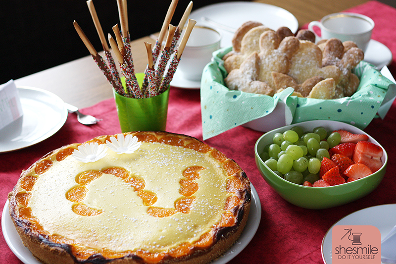 Einen kleinen, feinen, runden Käsekuchen mit Mandarinen-Stückchen zwei und zwei Esspapier Blüten. Bunte Zuckerperlen-Grissini-Stangen und Butterteig-Plätzchen im Duett mit einer Schüssel Trauben-Erdbeeren :D Es war ein bisschen Arbeit das alles herzurichten, aber ich finde es hat sich gelohnt.