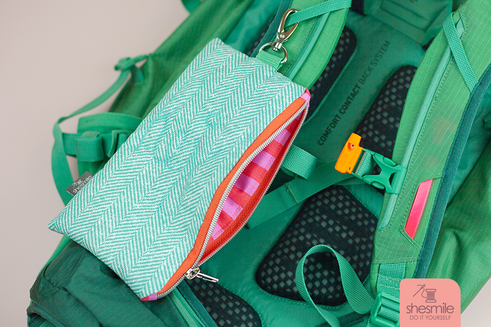 … und so sieht mein fertiges "Täschchen Luna" dann am Rucksack aus. Der Karabiner kann ganz einfach am Tragegurt eingeschnappt werden. Das Täschchen inklusive Handy hängt somit immer griffbereit. Der Reißverschluss lässt sich schnell und einfach nach unten öffnen und das Handy entnehmen.