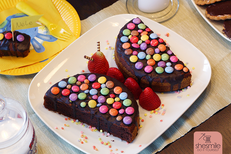 Ein Schokokuchen-Schmetterling mit Smarties und Erdbeeren. Gebacken und dekoriert zum Kindergeburtstag von shesmile.