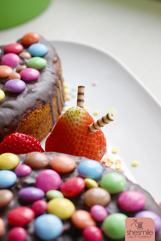 Ein Schokokuchen-Schmetterling mit Smarties und Erdbeeren. Gebacken und dekoriert zum Kindergeburtstag von shesmile.