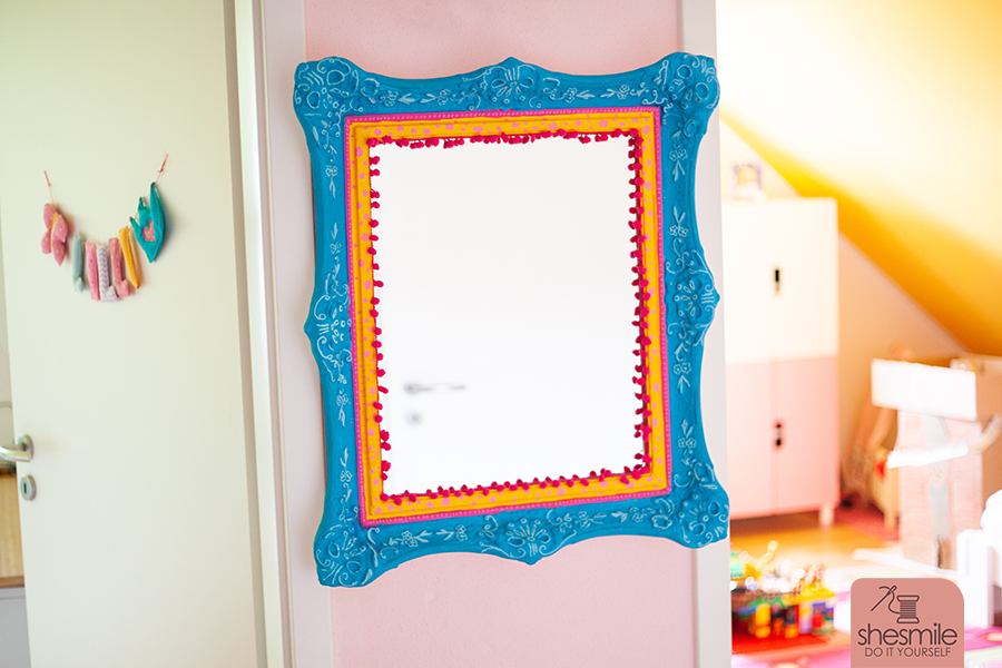 Ein Spiegel nach Maß mit Bommelborte. Ein alter Bilderrahmen wird zum Spiegel für das Kinderzimmer. Ein Upcycling Bastelprojekt von shesmile DIY.
