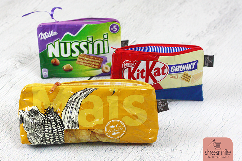 Taschen und Reißverschluss-Täschchen aus alten Verpackungen von Milka, Süßigkeiten, Maiswaffeln, Schokolade und Chipstüten nähen. Eine kostenlose Nähanleitung mit Tipps und Tricks mit Buchfolie von Melie von GrünBlauMeliert und Lisse von shesmile.
