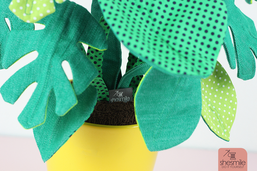Eine Zimmerpflanze Frieda Flower, Version Monstera nähen. Eine Nähanleitung mit Schnittmuster von shesmile. Pflanzen aus Stoff. Perfekt für Allergiker, das Kinderzimmer, Vielreisende, kranke und alte Menschen, schattige Plätzchen oder einfach nur Pflanzendummies wie mich! Als Geschenk oder für sich selbst. Ein super Nähprojekt für die Stoffrestekiste und lässt sich an jede Blumentopfgröße ganz einfach anpassen. Diese Zimmerpflanzen muss man nicht gießen, umtopfen oder pflegen. Sie wachsen auch nicht über deinen Lieblingsblumentopf hinaus. Die Blätter werden nicht braun und kleine Fliegen in der Erde kannst du hier lange suchen. Klingt perfekt? Finde ich auch!