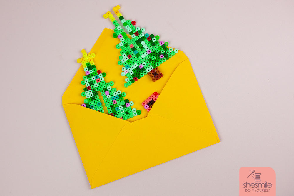 Noch nicht zusammengesteckt passt der Weihnachtsbaum auch prima in einen Umschlag und lässt sich so ganz einfach mit der Post verschicken. Als DIY-Weihnachtsbaum-Gruß sozusagen. Der Beschenkte braucht den Baum dann nur noch zusammenstecken und kann die Geschenkidee aufstellen und sich daran erfreuen.