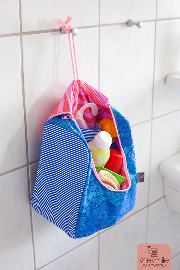 An den Bändeln lässt sich die Tasche im geöffneten Zustand aufhängen.