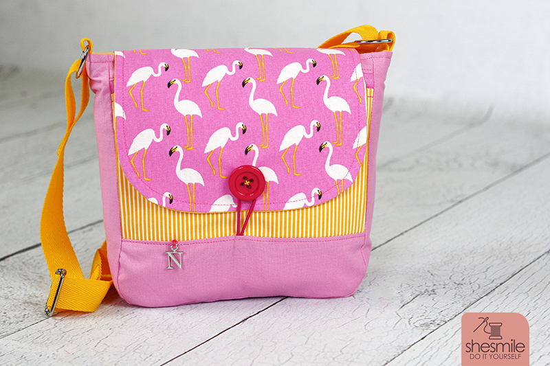 Eine Handtasche Ulla als Kindergartentasche für meine Tochter. Diesmal pinke Flamingos von Tedox mit gelb-weiss-gestreifter und pinker Baumwolle. Gummikordel- und Knopfverschluss. Ohne Reißverschluss. Eine Nähanleitung mit Schnittmuster von shesmile. Einfach. Kreativ. Nähen & Basteln.