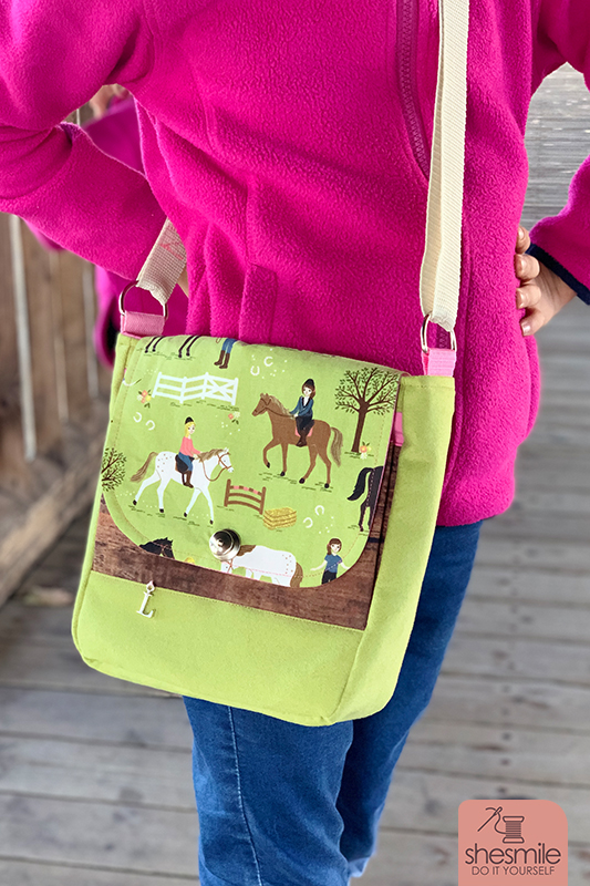Eine Handtasche Ulla aus Pferdestoff für meine Tochter. Diesmal Reiterhof Stoff in grün von Tedox mit Baumwolle in Holzoptik. LOX-Verschluss und Buchstabenanhänger. Ohne Reißverschluss. Eine Nähanleitung mit Schnittmuster von shesmile. Einfach. Kreativ. Nähen & Basteln.