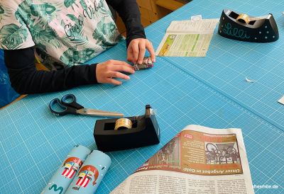 Wenn es 2x 24 Päckchen für die Cousins bzw. Neffen einzupacken gilt helfen meine Töchter inzwischen gerne mit.  Wir verwenden Zeitungspapier, Geschenkpapier und bemaltes Kopierpapier zum Einpacken der Päckchen.