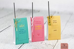 Druckvorlage und Bastelanleitung gestaltet als PDF-E-Book von shesmile für Tischkarten mit eingesteckten Wunderkerzen und Schleifchen. Zum Geburtstag, Jubiläum, Silvester, Weihnachten, Taufe, Konfirmation, Kommunion oder zur Hochzeit. Es gibt viel zu Feiern das ganze Jahr. Wenn Menschen zusammenkommen soll der Tisch schön dekoriert sein. Eine schnell gemachte DIY-Idee sind Tischkarten zum Aufstellen mit angesteckten Wunderkerzen.