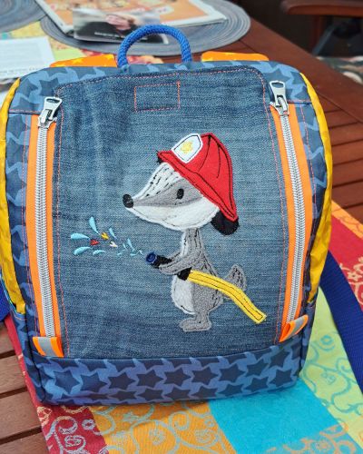 Ich habe den kleinen KlapPack als Kindergartenrucksack für meinen Großneffengenäht. Seine Mama ist eine Feuerwehrfrau und hat ihren Sohn ebenfalls mit dem "Feuerwehrvirus" infiziert. Für den Rucksack habe ich zum Teil alte Jeans- und Baumwollreste sowie beschichtete Stoffe von Farbenmix verwendet. Die Stickdatei ist der Feuerwehrdachs von GroWidesign.