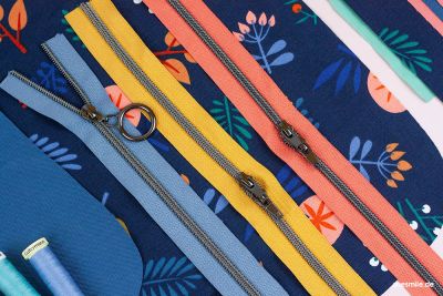 Reißverschluss in 6,5 mm Raupe, metallisiert in gunmetal. Erhältlich in 35 verschiedenen Farben. Hier zu sehen in Koralle, Senf und Blassblau. Zipper in gunmetal mit glattem Ring, ebenfalls von Snaply.