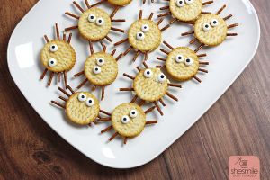 Alles was du brauchst sind Cracker-Kekse, Salzstangen, Augen und eine streichbare Creme. Damit erstellst du lustige Spinnen-Cracker für die Kinder-Halloween-Party.
