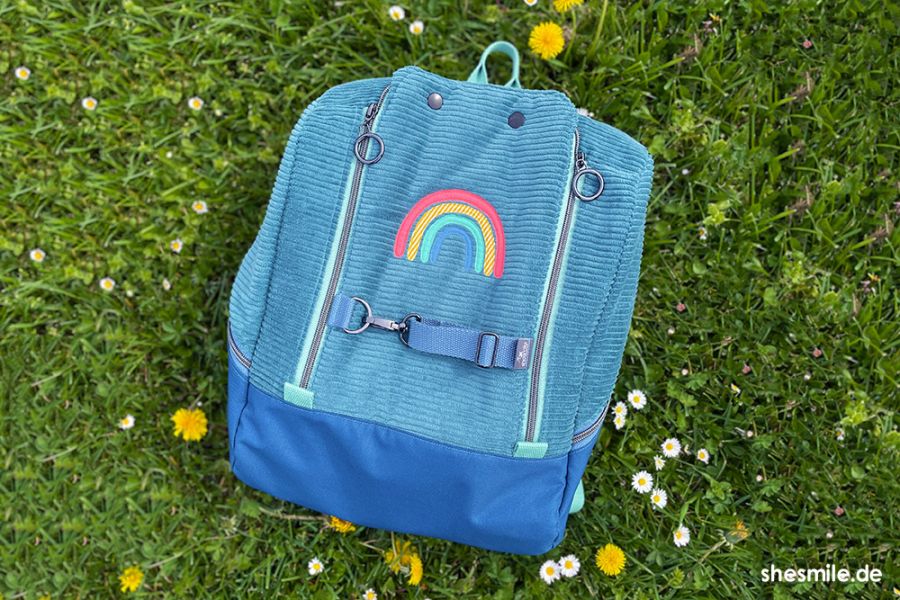 Nähanleitung und Schnittmuster von shesmile DIY. Einen Rucksack MidiKlapPack mit Flaschentasche und Jackengurte nähen. Mit Regenbogen Applikation. Aus Cord.