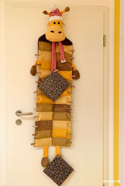Je nach Patchwork- und Farbkombination ist Gustav ganz einfach umsetzbar als Giraffe, Rentier oder Kuh. In den 24 kleinen Fächern lässt sich so einiges verstecken. Wer mag kann zusätzlich Klorollen einschieben, so kann das Geschenk nicht ertastet werden, und es gibt eine tolle Form. Mit nur einer Halteschlaufe hinter dem Kopf kann der 1,30 m lange Adventskalender ganz einfach an Türhaken oder Garderoben befestigt werden.