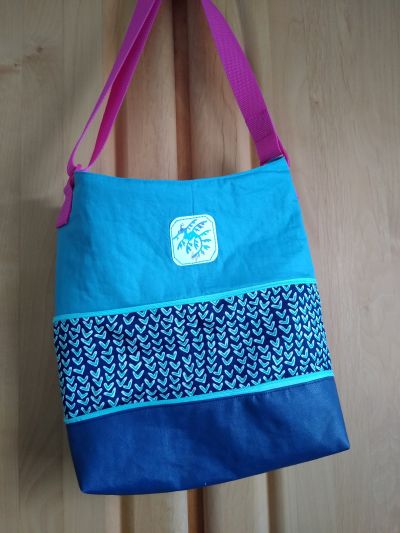 Als ich das Schnittmuster gesehen habe, war ich sofort begeistert... Als Mutti kennt man das ja, vor allem wenn man Familienmitglieder der Kategorie "Jäger & Sammler" begleitet, die selbst natürlich keine Tasche dabei haben... Dann ist Mamas Handtasche schnell zu klein. Ab sofort kann ich diese jetzt groß zaubern ;-) Und noch dazu idealer Schnitt um verschiedene Stoffe und Farben zu kombinieren. Der umlaufende Reißverschluss setzt einen ganzen besonderen Akzent. Und tatsächlich hatte ich alles was verarbeitet wurde Zuhause rumliegen. Statt der D-Ringe habe ich die alten Verstellschnallen einer ausrangierten und löchrigen Matschhose genutzt, so ist der Gurt zwar nicht abnehmbar, aber dafür fest installiert und trotzdem verstellbar in der Länge. Vielen Dank für den tollen Schnitt, Anleitung ist super geschrieben, alles gut und gründlich erklärt 👍 Achso und die kleinen Falten auf der Rückseite sind getreu dem Motto "perfekt unperfekt" da reingenäht worden ;-)