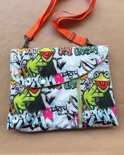Bei dieser Tasche handelt es sich um eine Smartkram-Tasche in der Größe 16“. Das Projekt lag leider längere Zeit als UFO in meiner Nähecke. Die Mitmachaktion war nun die Motivation, die Tasche fertigzustellen. Als Materialien wurden außen Softshell und innen Baumwollstoff sowie Mesh-Netzstoff verwendet. Wichtig war mir bei diesem Projekt ein farbenfrohes Design. Die letzten Nähte wurden geschlossen, das Gurtband fertiggestellt und die Tasche ist nun einsatzbereit.