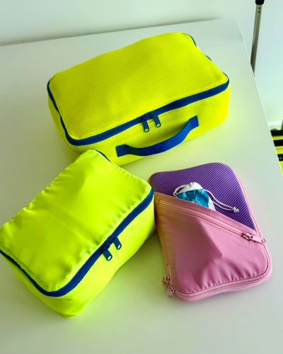 Ich habe Air Mesh (von Snaply und Aktivstoffe) verwendet, kombiniert mit Baumwollstoff, Nylon-Futtertaft und auch mit grobem Mesh aus meinem Fundus. Bei den von mir verwendeten Reißverschlüssen handelt es sich um Meterware von YKK (Vislon mit 6 mm Raupe). Das ist mein liebster Reißverschluss, denn er hält gut und auch Kinder können ihn prima handeln. Das Airmesh und ich sind nicht so gute Freunde geworden, denn durch die Dehnbarkeit lässt sich zwar der Rund-um-Reißverschluss sehr leicht annähen, aber es fusselt so sehr. Das grobe Mesh (von FunFabric) habe ich dadurch gebändigt, dass ich es zuerst mit Geradstich und dann mit einem elastischen Zickzack festgenäht habe. Es hält jetzt. Zum Nähen habe ich hauptsächlich meine Performance Icon von Pfaff (gekauft bei der Nähwelt Flach) benutzt. Mit dem Universalnähfuß und dem Reißverschlußfuß genäht. Auch meine Gloria von Babylock (gekauft bei Nähmaschinen Hörmann) kam für eine Naht Air Mesh auf Air Mesh testweise zum Einsatz und das hat richtig gut funktioniert. Alles richtig schnell zusammengenäht und versäubert in Rekordzeit im Vergleich zu Schrägband annähen.
Als Garn habe ich Allesnäher von Gütermann und Aerofil von Madeira verwendet. Es macht süchtig die Packwürfel zu nähen, denn irgendwann stellt man fest es passt tatsächlich perfekt in den Koffer und dann merkt man, dass man doch noch mehr Packwürfel brauchen könnte …