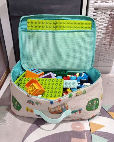 Ich hab die Idee mit dem Spielkoffer umgesetzt und für meine Kids einen Reisespielkoffer in Größe L mit 15cm Höhe für ihr Duplo genäht. Außen- und Innenstoff sind aus Canvas. Der Boden ist mit der Schaumstoffeinlage Style Vil verstärkt, Deckel und Rand mit H640 und H250. In den Deckel hab ich aus dem Mesh eine Tasche für die Duploplatten eingenäht.