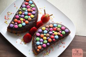 Ein Schokokuchen-Schmetterling mit Smarties und Erdbeeren