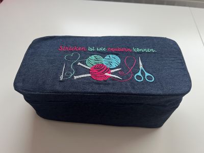 Ich wollte ein schönes Geschenk für eine Freundin gestalten. Sie strickt Socken und daher habe ich die KimKonsole ein bisschen angepasst, damit sie für‘s Stricken gut passt. Deckel und Boden sind beide mit Style-Vil Fix verstärkt. Der Einlegeboden hat Decovil bekommen und das Gummiband wurde so angenäht, dass mindestens 2 Nadelspiele Platz haben. Das obere Fach ist etwas schmaler geworden, dass recht für Zubehör (Schere, Nadel und co), dafür ist das untere breiter geworden, damit die Wolle mehr Platz bekommen. Verstärkt ist alles mit H250. Die Stickdatei kommt von RockQueen und wurde passend zum Verwendungszweck ausgewählt.