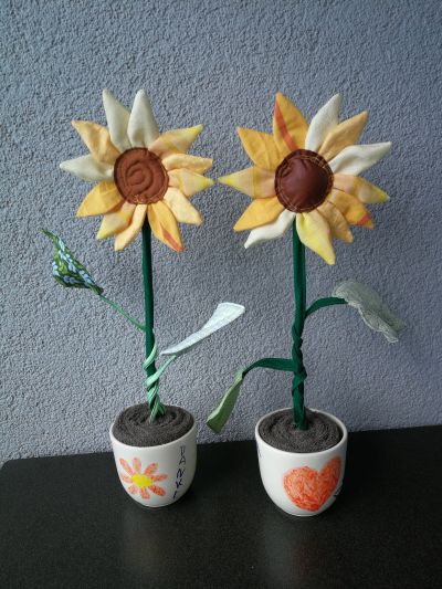 Pflanzen die Ewigkeit ohne, dass man sie (in meinem Fall) mühsam am Leben halten muss finde ich insgesamt eine super Idee! Außerdem brauchte ich ein Abschiedsgeschenk für die Erzieherinnen im Kindergarten. Meine Tochter war in der Sonnengruppe, da sind Sonnenblumen echt passend. Weil ich ein großer Upcycling Fan bin, habe ich die Blüten aus einer alten Bettwäsche und einem alten Vorhang, die Blätter aus Stoffresten und die Erde aus alten Handtüchern gemacht.