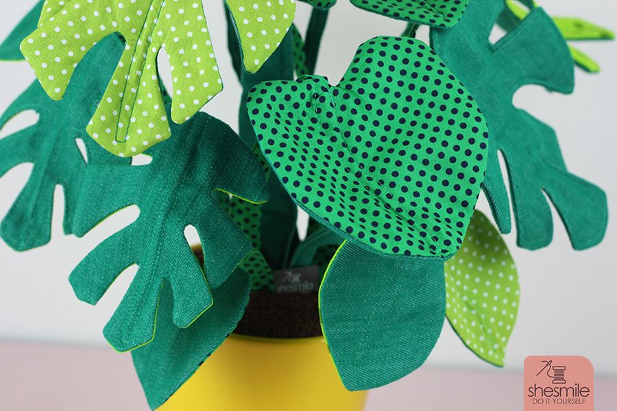 Eine Zimmerpflanze Frieda Flower, Version Monstera nähen. Eine Nähanleitung mit Schnittmuster von shesmile. Pflanzen aus Stoff. Perfekt für Allergiker, das Kinderzimmer, Vielreisende, kranke und alte Menschen, schattige Plätzchen oder einfach nur Pflanzendummies wie mich! Als Geschenk oder für sich selbst. Ein super Nähprojekt für die Stoffrestekiste und lässt sich an jede Blumentopfgröße ganz einfach anpassen. Diese Zimmerpflanzen muss man nicht gießen, umtopfen oder pflegen. Sie wachsen auch nicht über deinen Lieblingsblumentopf hinaus. Die Blätter werden nicht braun und kleine Fliegen in der Erde kannst du hier lange suchen. Klingt perfekt? Finde ich auch!