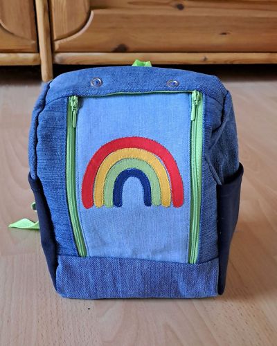 Mein Nähprojekt war der Rucksack KlapPack in der kleinsten Version als Geschenk für die Tochter meines Cousins zum Geburtstag und zur Kindergarteneingewöhnung. Da die Kleine in die Regenbogengruppe soll, war natürlich klar, dass ein Regenbogen auf dem Rucksack nicht fehlen darf. Besonders gefreut hat es mich, dass ich alle verwendeten Stoffe im Bestand hatte und mit dem Jeansstoff alte Jeanshosen ein neues Leben gefunden haben. Als praktischen Hack in der Anwendung sind die Trinkflaschenfächer an der Seite einfach aus Bündchen zugeschnitten.